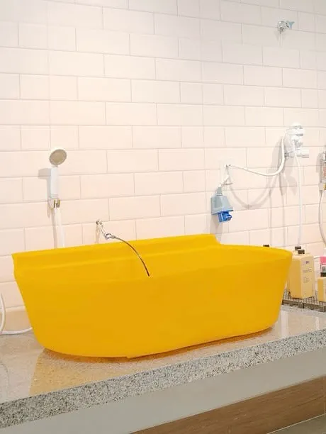 Banheira amarela com ducha no salão da Amoreco